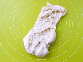 之后倒在揉面垫上，用手掌根部向前一直推揉面团，手揉面团刚开始都比较粘手，揉一会就会好些