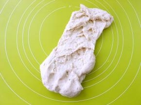 之后倒在揉面垫上，用手掌根部向前一直推揉面团，手揉面团刚开始都比较粘手，揉一会就会好些