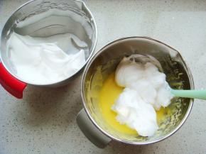 把打好的蛋白分一半倒入蛋黄糊糊里。呈“J”字形翻拌，不可划圈避免消泡。