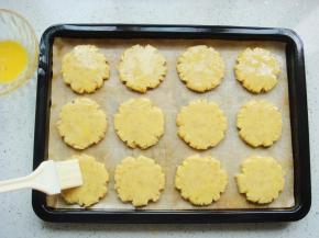 用刮板把饼胚移到铺好油布的烤盘里，之间要留有缝隙，烤的时候会涨大一些。表面均匀的刷上剩余的鸡蛋液。