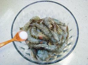 虾剪掉虾须和虾剑，挑去虾线，清洗干净，加入盐。