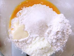 容器内加入高筋面粉，低筋面粉，全蛋液，细砂糖，奶粉，炼乳，加牛奶用筷子搅拌至棉絮状