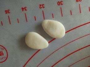 取2个分别是2克的面团，揉成水滴状，稍微按扁，做兔子的手部