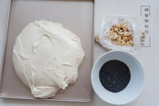 将打好的面团倒出，叠入需要的核桃仁及熟的黑芝麻