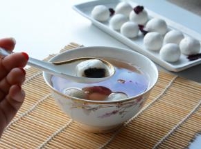 汤圆冒鱼眼泡的时候，放进去小火煮好，浮起来，再关火闷2分钟。
沏一朵墨红茶水。滤除茶汁，将煮好的汤圆放入。一碗芝麻玫瑰汤圆就好了。