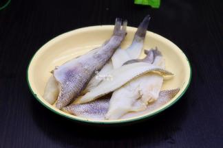 解冻好的冰鱼柳，用清水冲洗干净，用刀从中间切块，就是鱼的对半切，这样烤的时候方便，