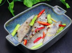 腌制好饼鱼块，均匀放入烤盘，再把洗净的芦笋、辣椒均匀铺上。撒上孜然粉。