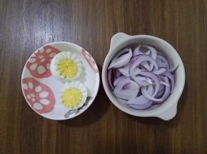 4、晾凉的鸡蛋去蛋壳，用小刀刻成花形，洋葱切丝备用。