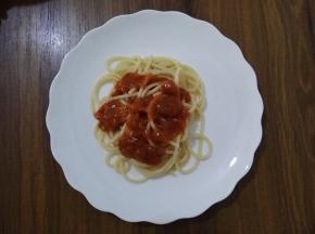 6、待面酱温热后，撕开包装，将面酱挤在意大利面上。