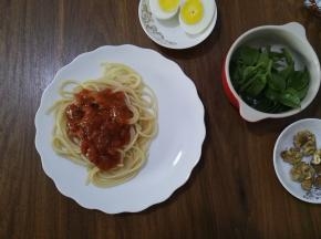 5、将意面捞出放入盘中，撕开肉酱的包装，倒在意面上。