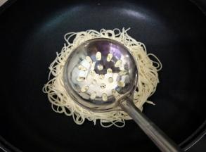 放上一个漏勺在面条上。