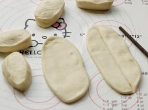 把面剂子揉圆搓长成柱状，按扁，然后再擀开成为椭圆的面片，不需要擀太薄，然后用筷子在中间按一下，按出一个压痕，这是为了拉开时候可以从中间轻易分开成两根，避免面条太宽。