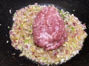 洋葱丁炒至透明后加入猪肉馅，快速翻炒滑散肉馅