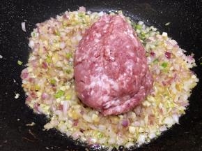 洋葱丁炒至透明后加入猪肉馅，快速翻炒滑散肉馅