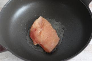 不沾锅内倒入适量食用油，放入鸡肉小火煎制。