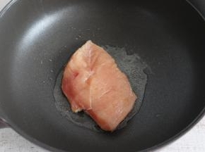 不沾锅内倒入适量食用油，放入鸡肉小火煎制。