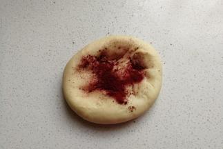 接下来把大份的面团加入适量红曲粉揉均匀，揉成红色的面团，然后再把两份面团分别放入两个容器中盖保鲜膜进行发酵。