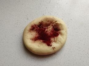 接下来把大份的面团加入适量红曲粉揉均匀，揉成红色的面团，然后再把两份面团分别放入两个容器中盖保鲜膜进行发酵。