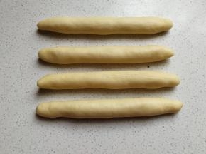 先把静置好的白色面团搓成长条状。