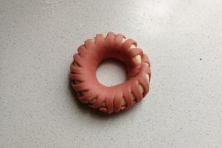 编好后围成圆环，首尾处沾点水粘起来，然后摆入烤盘中，再继续做完剩下的三个花环包，然后都摆入烤盘中进行发酵。