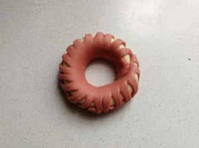 编好后围成圆环，首尾处沾点水粘起来，然后摆入烤盘中，再继续做完剩下的三个花环包，然后都摆入烤盘中进行发酵。