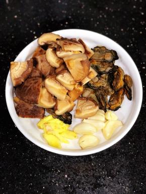冬菇泡发好，这次用的冬菇比较大，我切成4块了。蚝豉洗净备用。姜拍扁，几个蒜头米粒。
