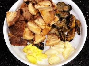 冬菇泡发好，这次用的冬菇比较大，我切成4块了。蚝豉洗净备用。姜拍扁，几个蒜头米粒。