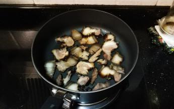锅里放入熏肉翻炒一会