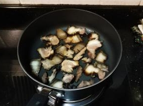 锅里放入熏肉翻炒一会