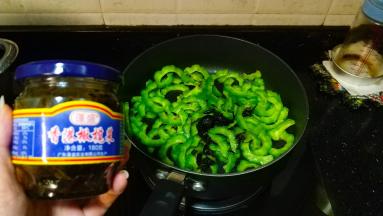 放入橄榄菜、糖翻炒至熟透