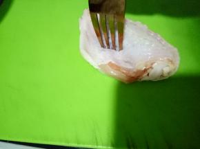 用厨房纸吸干多余的水份后拿个叉子在鸡翅上面叉叉叉，这样可以帮助鸡翅更好的吸收调料（也可以用刀划几下，但那样影响美观）