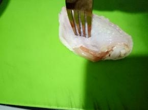 用厨房纸吸干多余的水份后拿个叉子在鸡翅上面叉叉叉，这样可以帮助鸡翅更好的吸收调料（也可以用刀划几下，但那样影响美观）