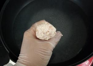 锅中坐水烧开，转小火，用虎囗将其挤成丸子