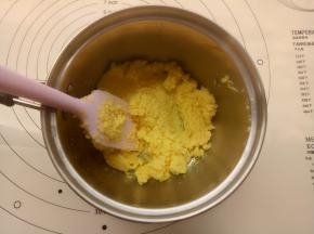 趁面团一发的时候来制作椰蓉馅：把黄油、白糖和牛奶放入小锅里小火加热至融化后离火，放入蛋黄液搅拌均匀，放入椰蓉拌均匀备用。