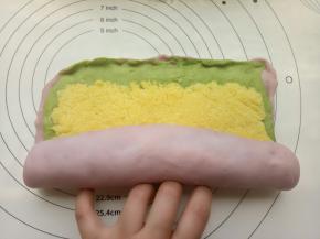 把椰蓉馅均匀的平铺在擀好的面团上，然后卷起来。