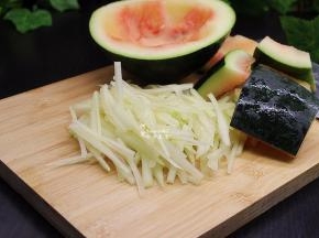 大红西瓜用勺子把西瓜肉挖出来，再用刀把西瓜的少许红肉刮干净，绿皮也用刀切干净，然后用清水洗净，沥干水，切成丝，越细越好。