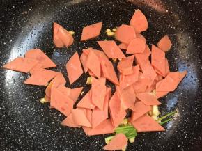 放入火腿肠，炒香