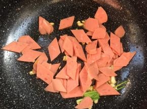 放入火腿肠，炒香