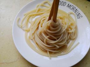 4.	来给意面造个简单的型吧，把筷子放在意面中间，然后朝着一个方向转动筷子，这样意面就造好型啦，