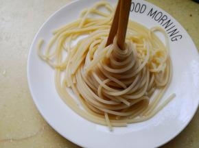 4.	来给意面造个简单的型吧，把筷子放在意面中间，然后朝着一个方向转动筷子，这样意面就造好型啦，