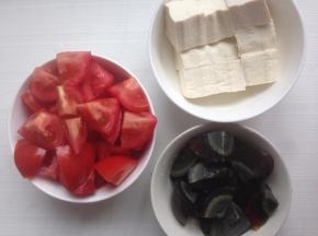 豆腐切成小块，番茄去蒂切块，皮蛋蒸熟后去壳，切小块
