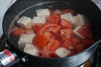 锅里的水烧开后，放入豆腐和番茄，加点盐，煮2、3分钟，不用煮太长时间