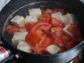 锅里的水烧开后，放入豆腐和番茄，加点盐，煮2、3分钟，不用煮太长时间