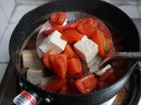 将番茄和豆腐捞起，倒去水，将番茄豆腐放回锅里