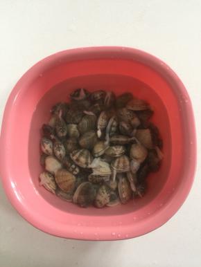 挑选活花甲放在盆里加入适量的盐浸泡半天，让花甲把肚肚里的泥沙吐干净。