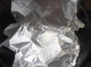 麦饭石不粘锅烧热倒入少许的油，铺上锡纸。