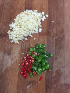 蒜瓣剁成蒜末，青尖椒和红米椒切成圈儿备用。