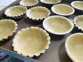 取大约25克的面团，放到容器中，带防粘手套，用拇指把面团和模具贴合起来，适当稍微高出模具。