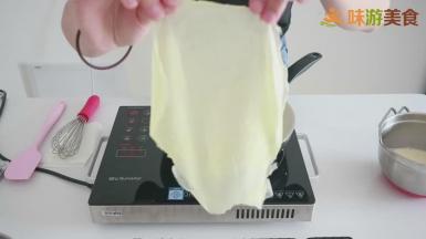 当面糊表面开始冒小气泡的时候就基本熟了，用硅胶刮刀轻轻铲起边缘，然后用手小心的拿起来，这样一张千层皮就做好了。放在晾晒架上摊平晾凉