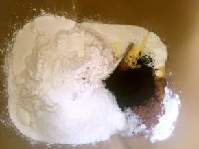 面包桶内加入高筋面粉，可可粉，竹碳粉，奶粉，酵母，细砂糖，全蛋液跟淡奶油